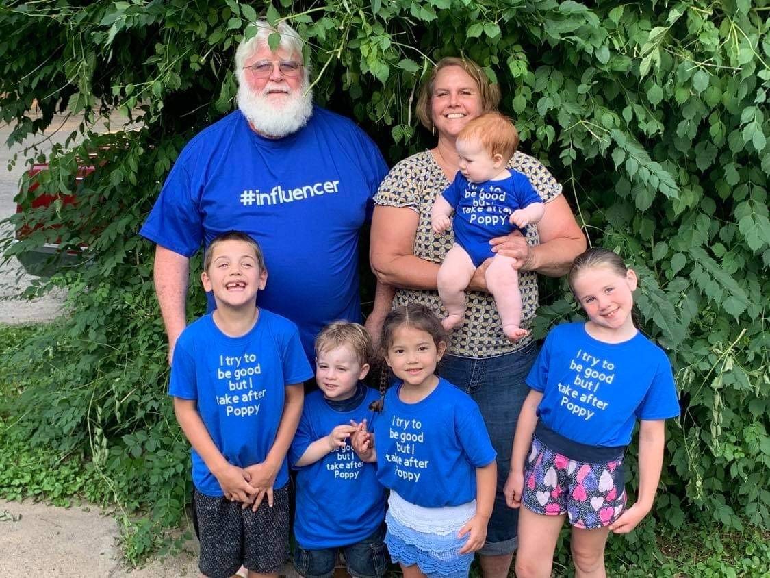 Mama and Poppy with all their grandchildren wearing matching blue shirts